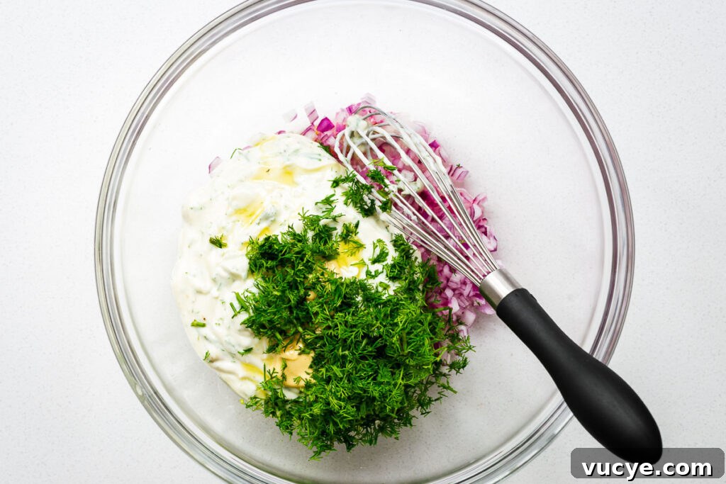 The ingredients for the creamy yogurt potato salad dressing in a large bowl.
