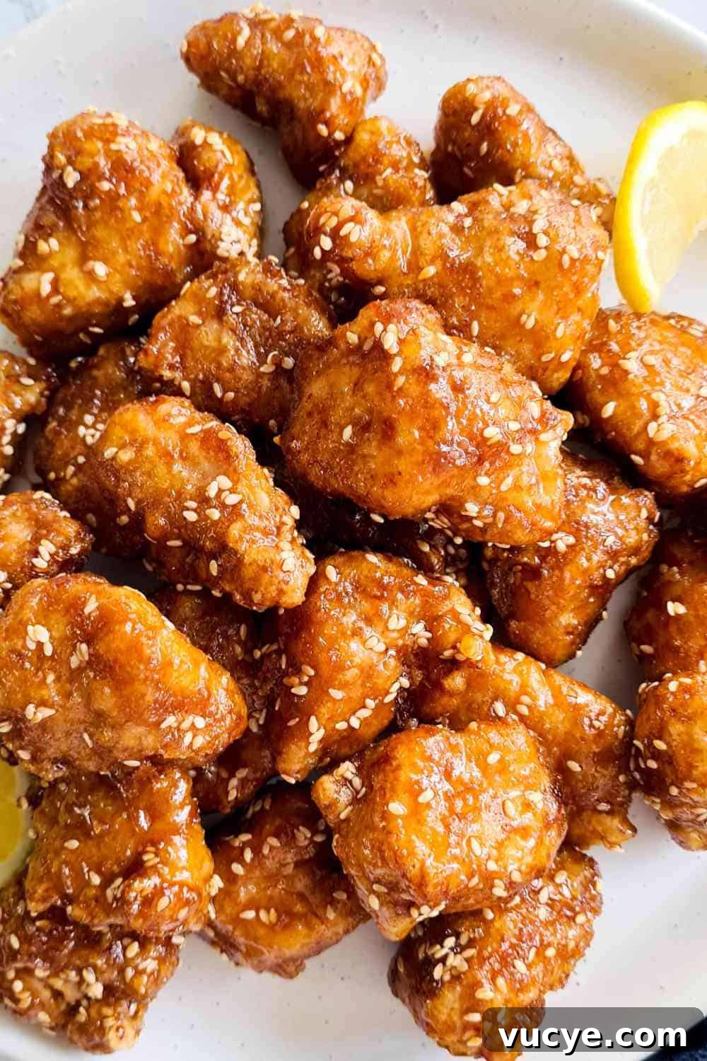 Crispy honey glazed chicken bites on a white plate