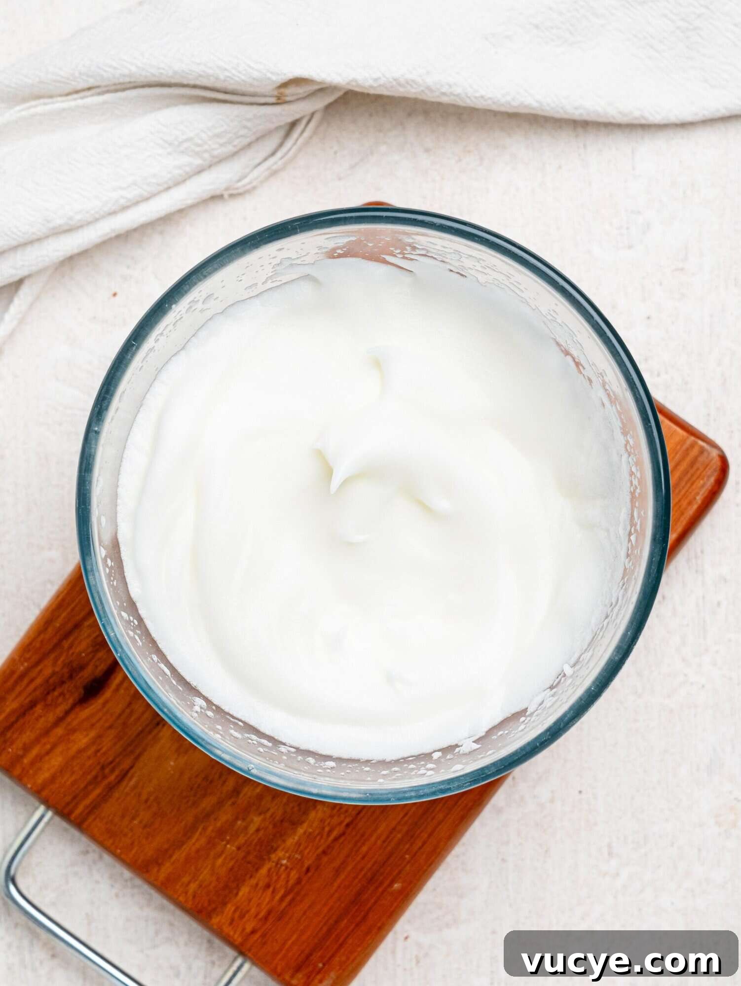 Whipped egg whites in a glass bowl.