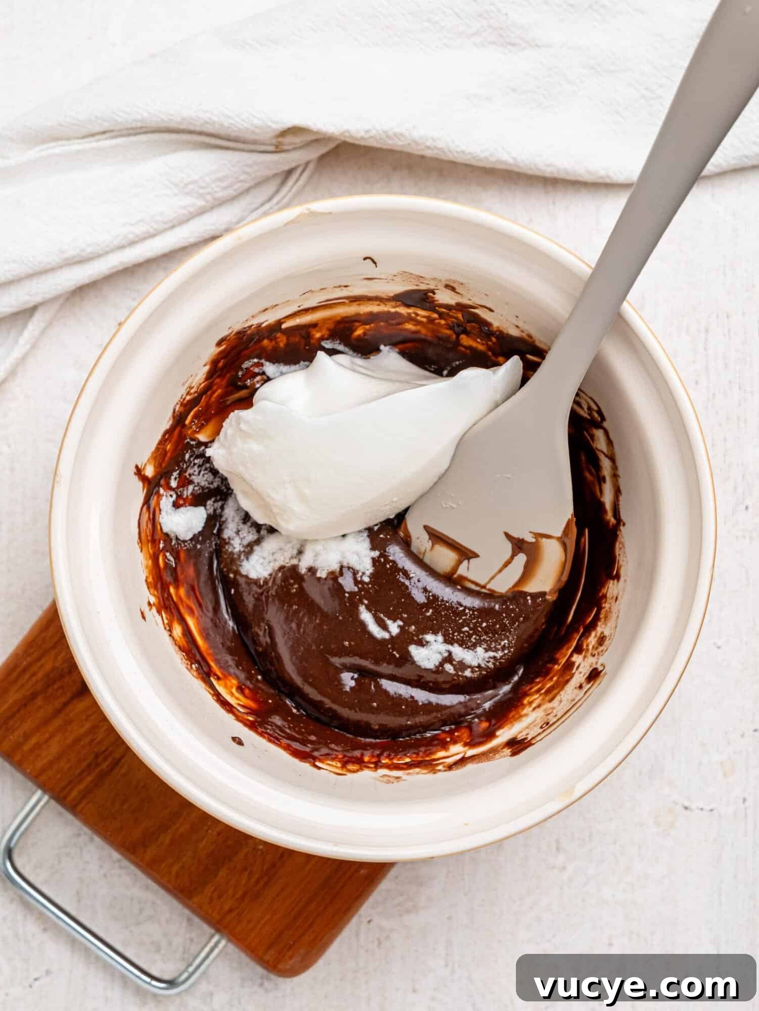 Mixing whipped egg whites into the chocolate mousse.