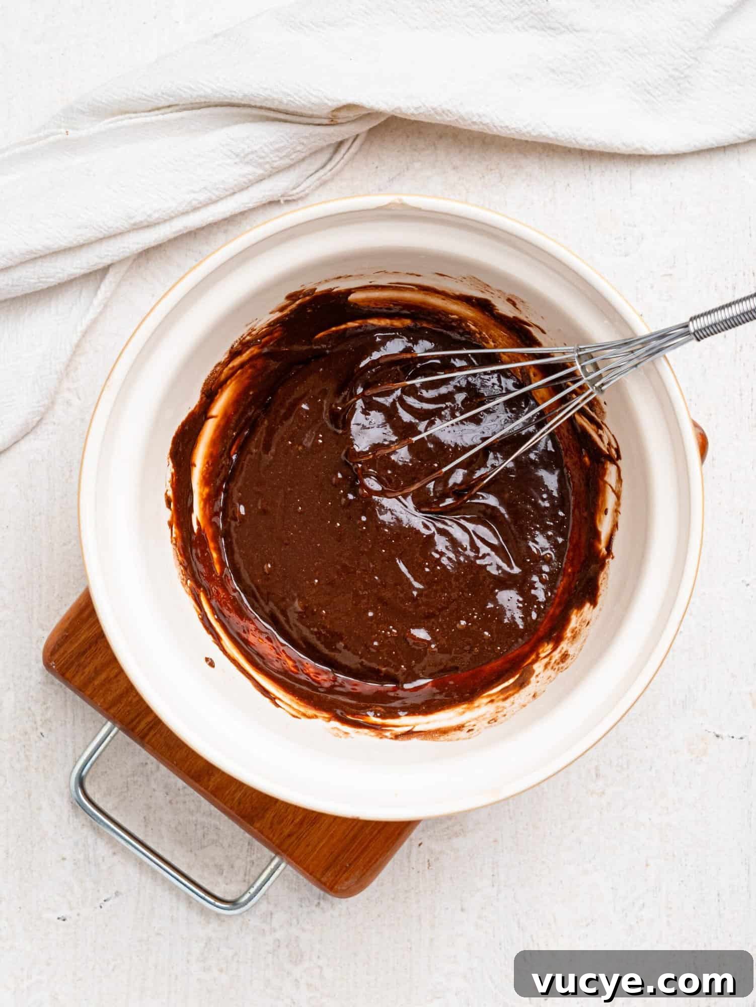 Melted dark chocolate, protein powder and milk in a mixing bowl.