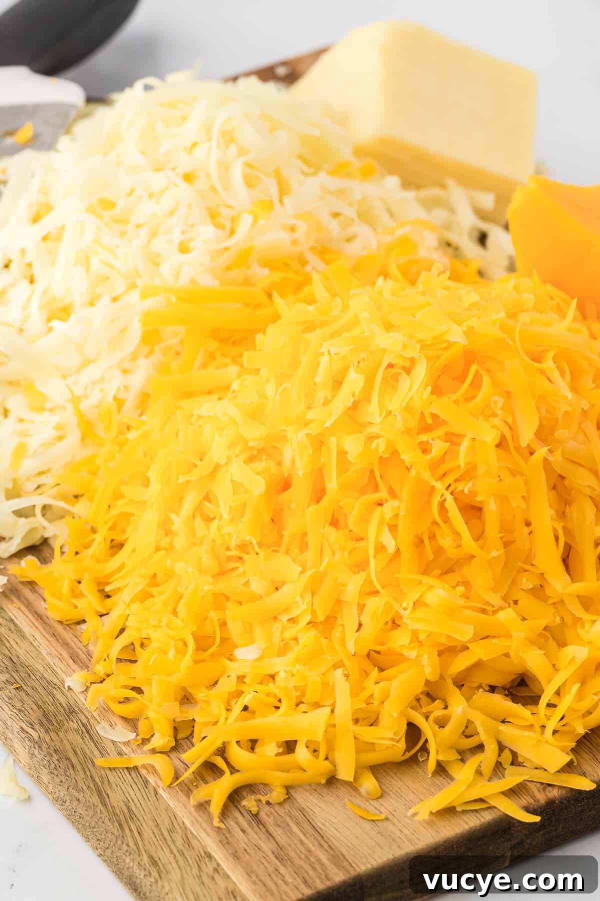 Creamy Baked Macaroni and Cheese Casserole Recipe 19 freshly grated cheese on a cutting board