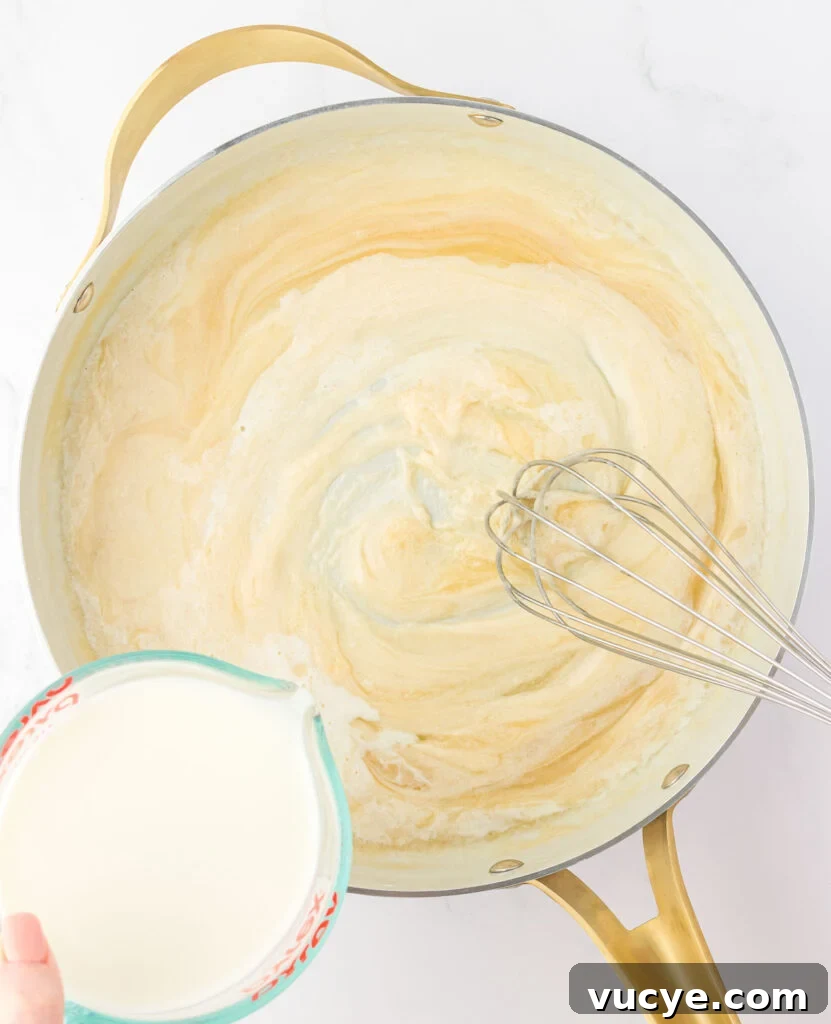Creamy Baked Macaroni and Cheese Casserole Recipe 8 adding milk to the roux