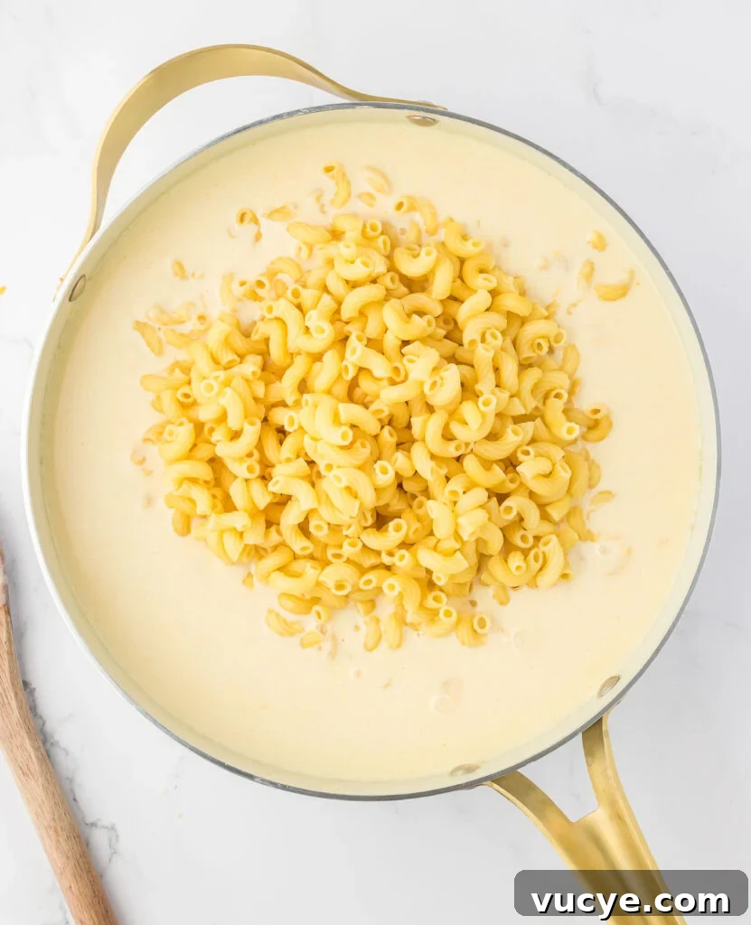 Creamy Baked Macaroni and Cheese Casserole Recipe 10 adding macaroni noodles to the cheese sauce