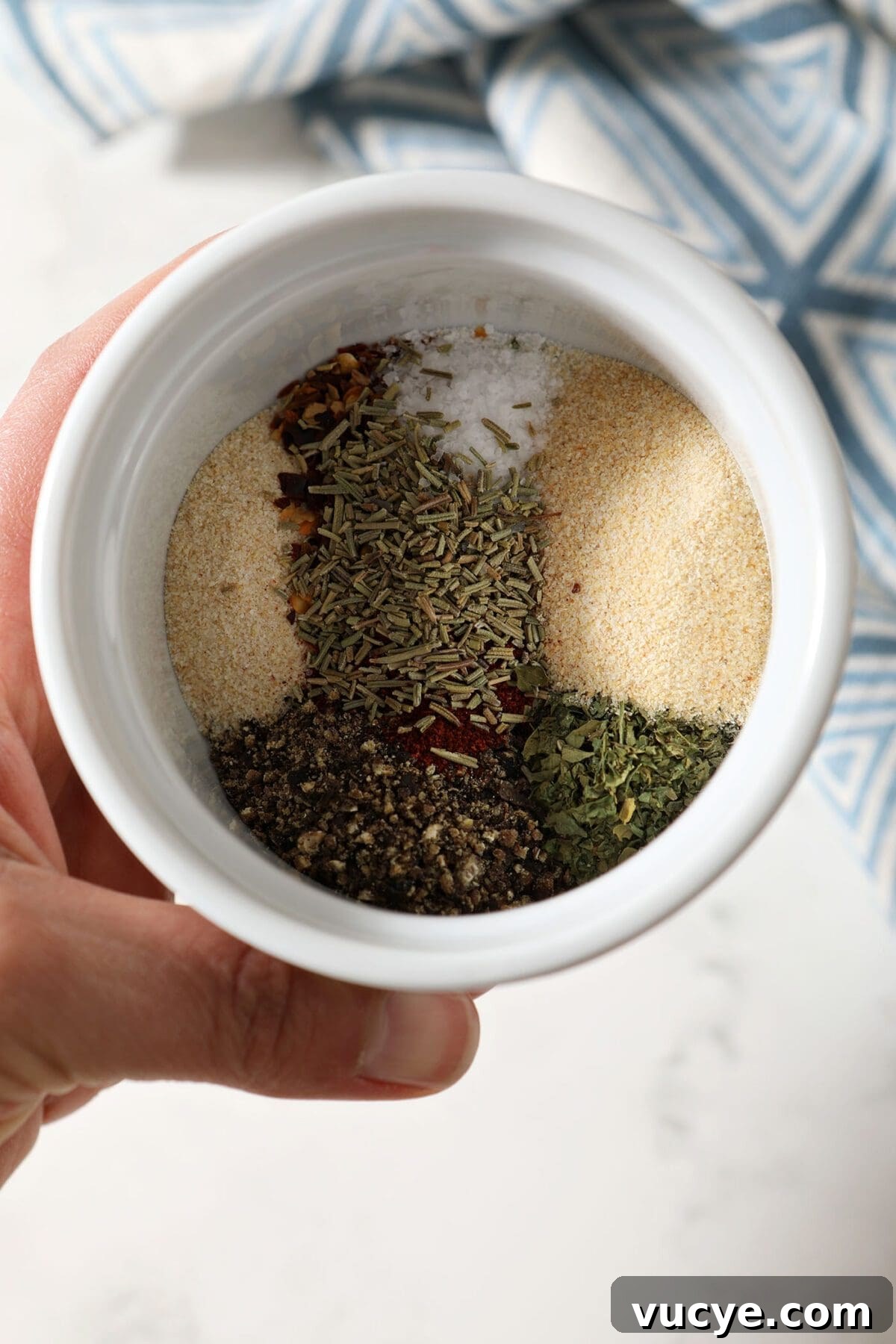 Ingredients to make a steak seasoning blend in a white bowl before mixing