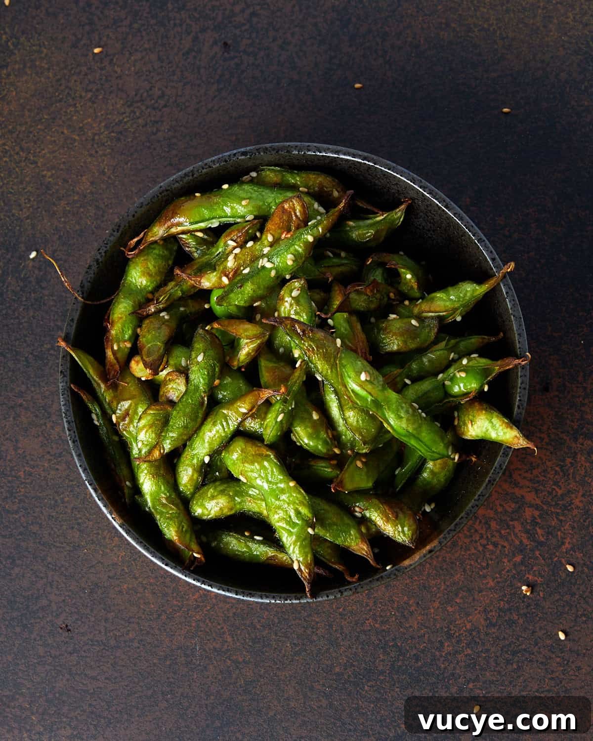 Crispy Air Fryer Frozen Edamame in 10 Minutes 2 Square overhead photo of a bowl full of air fryer roasted edamame beans in the pods.