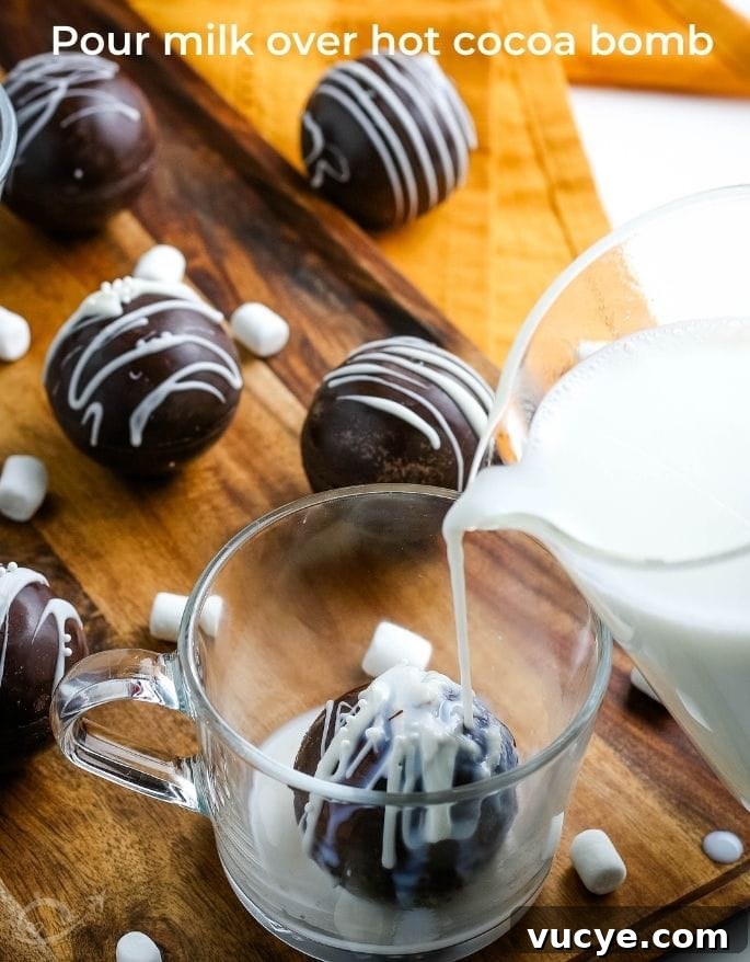 DIY Hot Chocolate Bombs Filled with Mini Marshmallows 8 pouring milk over a hot chocolate bomb in a glass mug