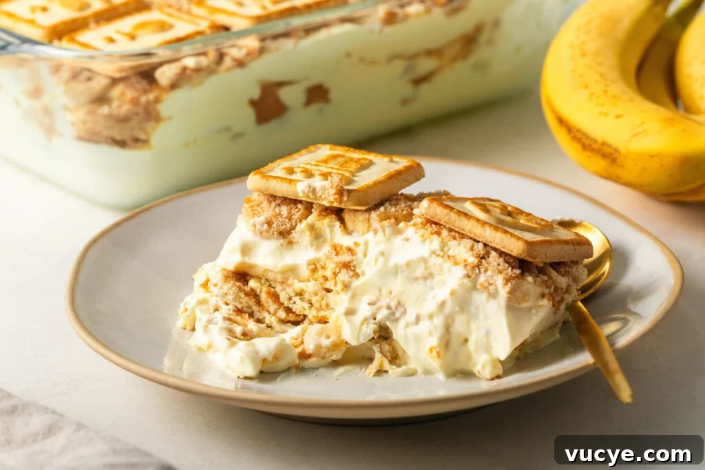 scoop of souther banana pudding with chessmen cookies on a serving dish with a gold spoon 