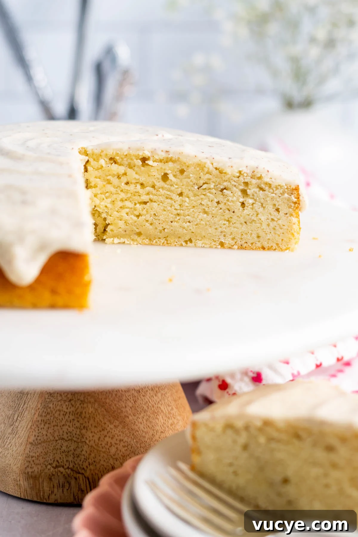 Moist Cardamom Cake Recipe with Warm Spices 2 sliced cardamom cake on cake stand