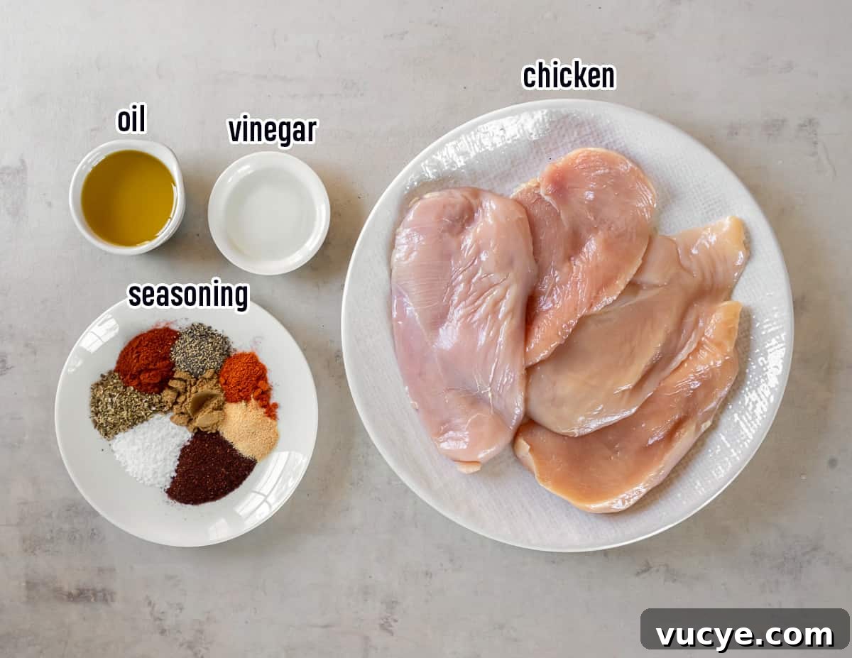 Smoky Chipotle Chicken Recipe: Juicy Grilled Chicken with Sauce 4 Boneless chicken breasts on a white plate next spices, oil, and vinegar in small bowls with text.