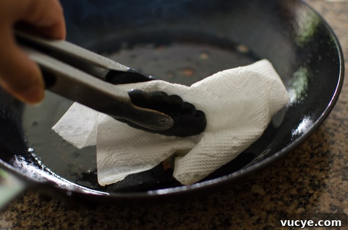 Spicy Pork and Squid Stir-Fry (Osam Bulgogi) Recipe 6 Wiping fat in a skillet with a paper towel.