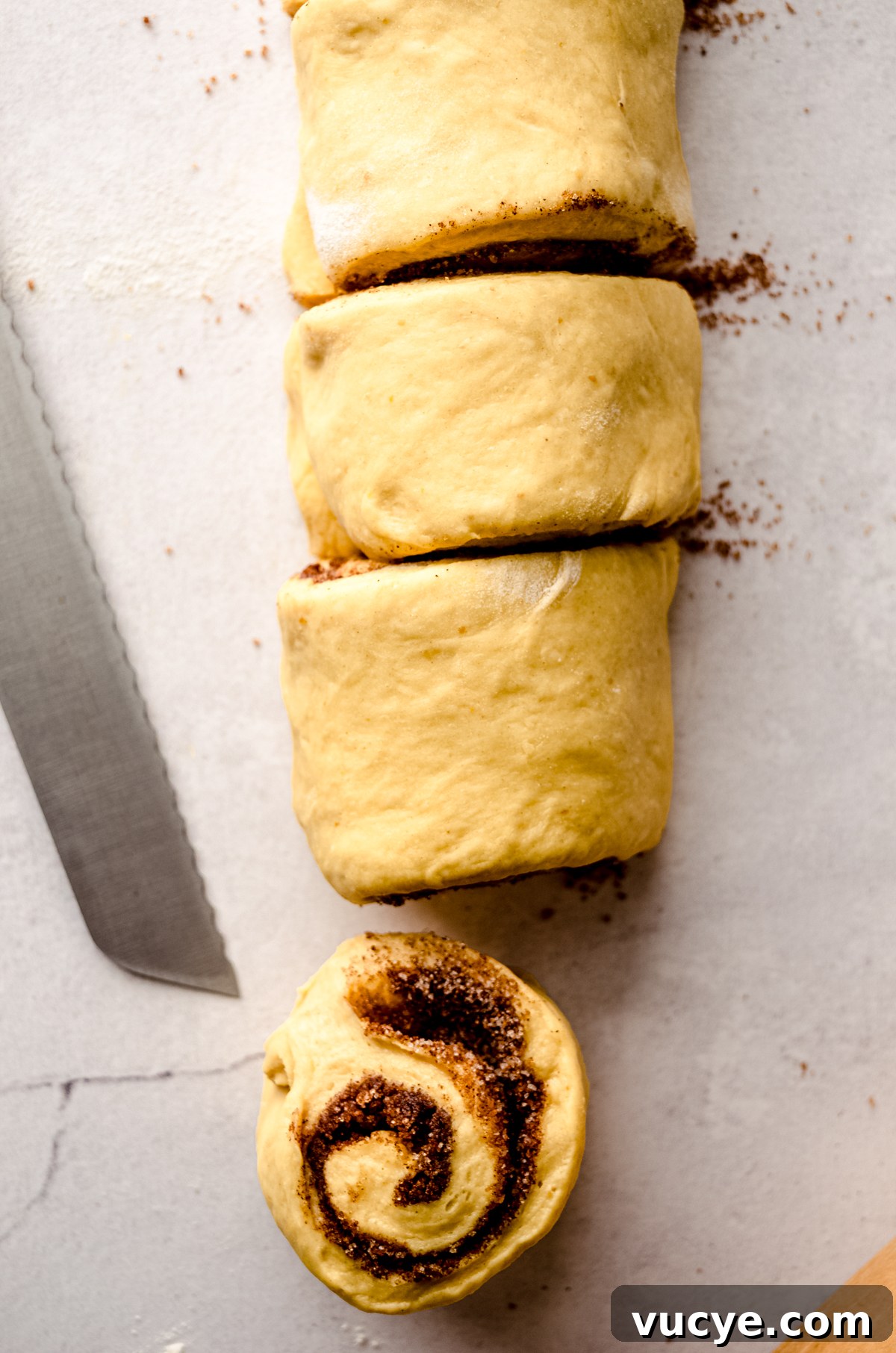 Aerial photo of a log of pumpkin cinnamon rolls that have been sliced.