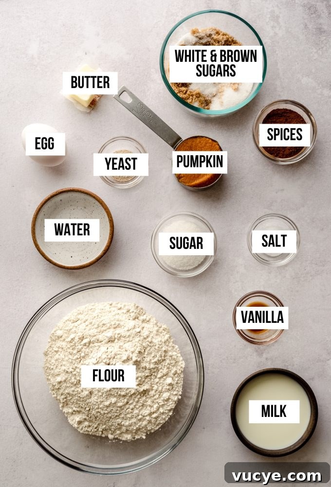 Aerial photo of ingredients to make pumpkin cinnamon rolls with text overlay labeling each ingredient. 