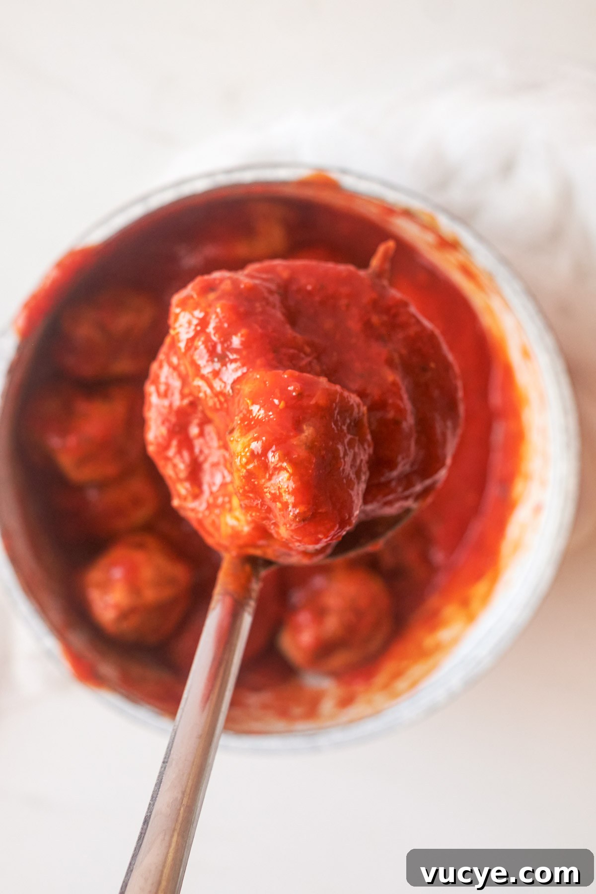 top down view of cooked frozen meatballs in a pan with sauce