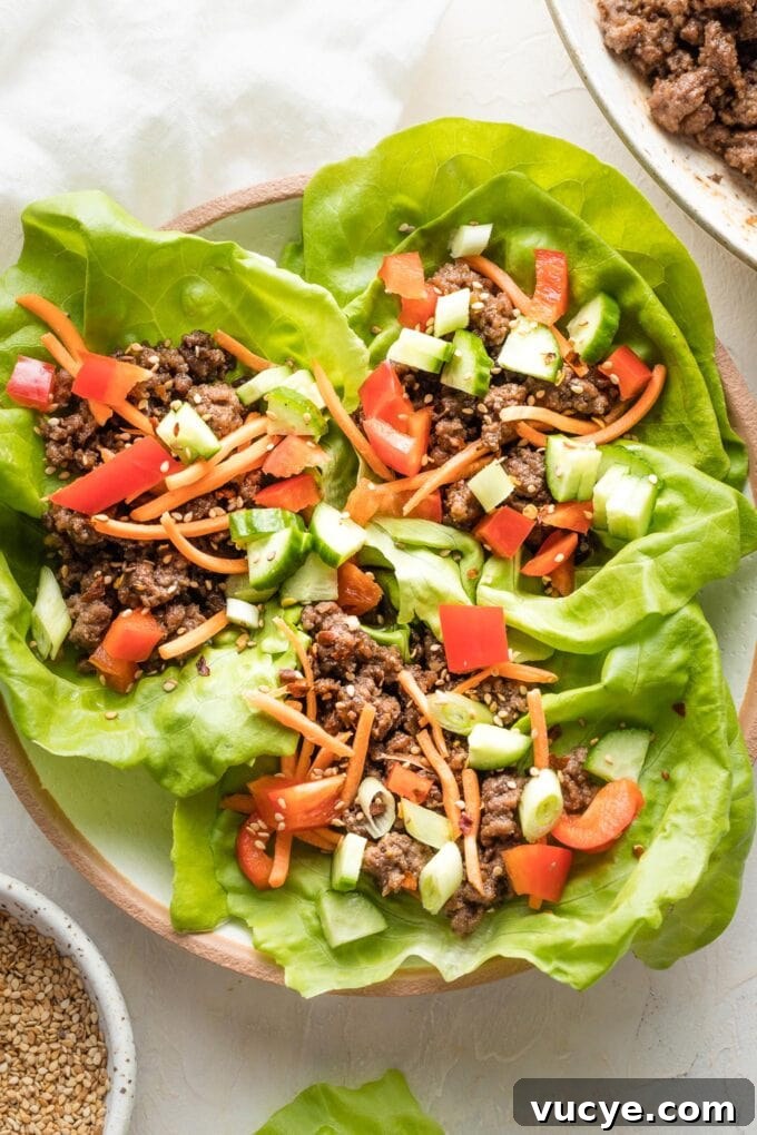 Three Korean beef lettuce wraps piled into a white bowl, ready to eat.