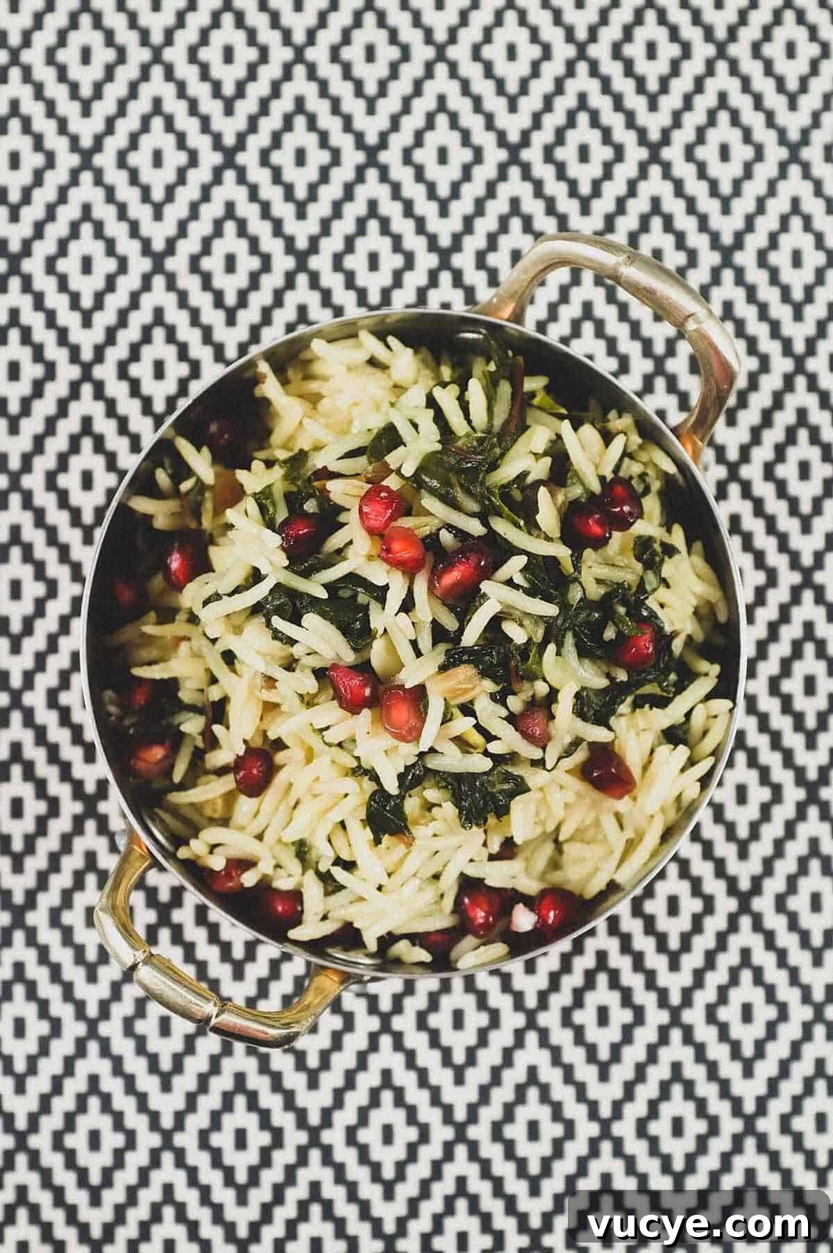 A small copper pot holds some Moroccan rice with Silverbeet, garnished with pomegranate seeds