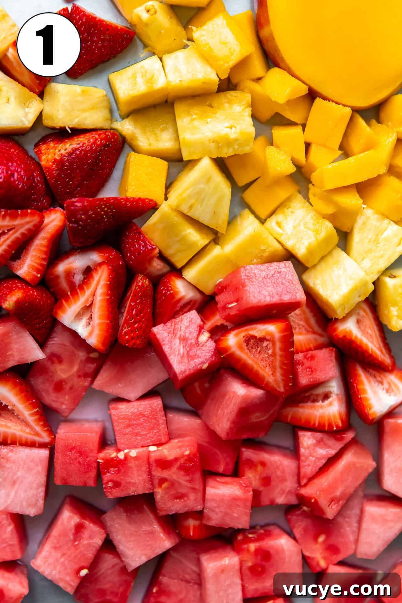 Chopped fruits laid spread out, watermelon, strawberry and mango.