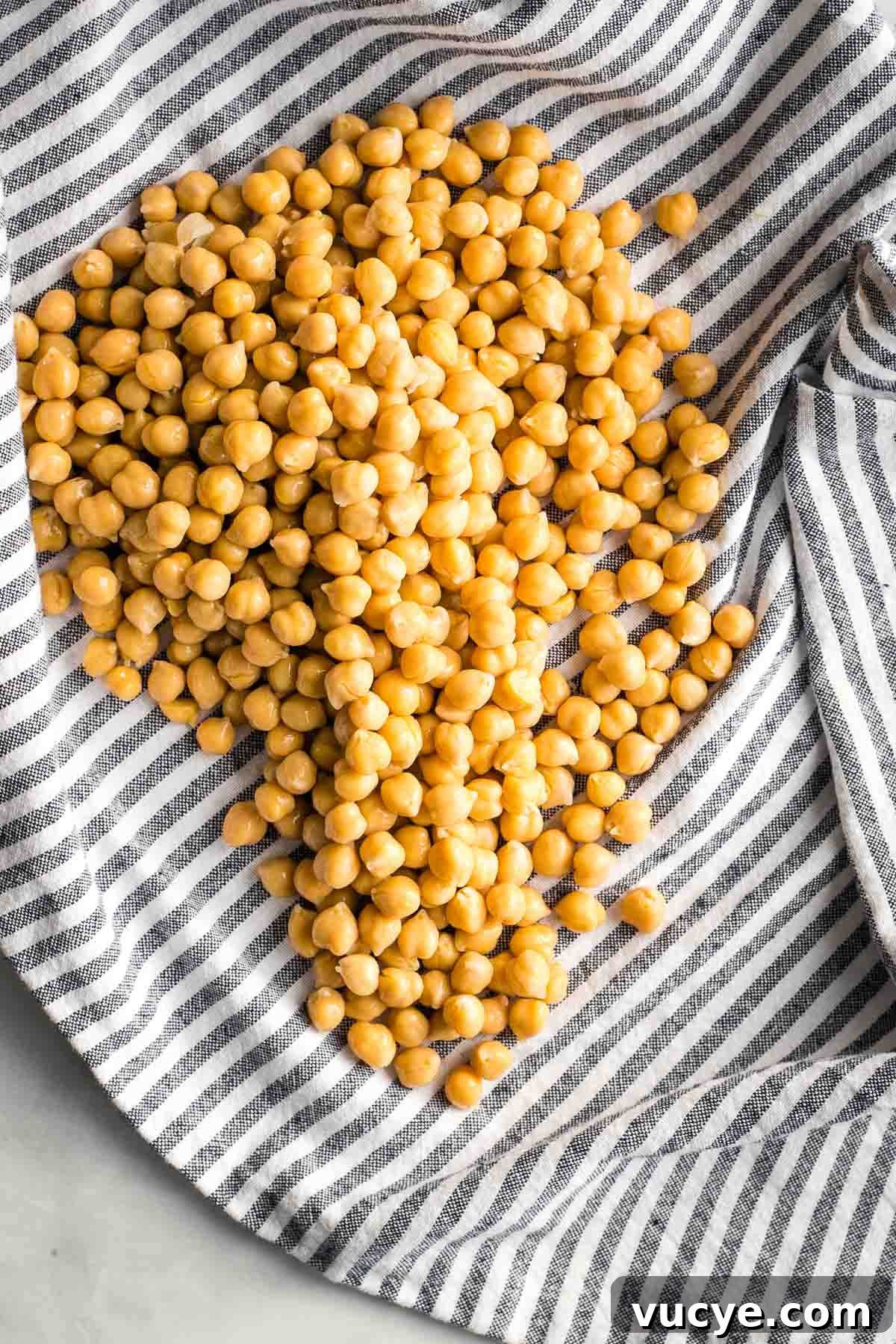 Canned chickpeas spread on a striped dish towel.
