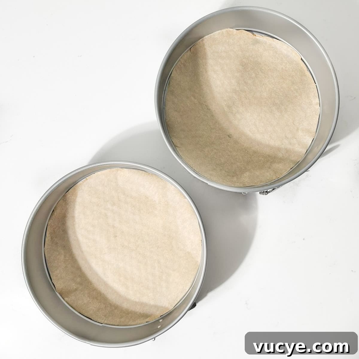 Two prepared round cake tins.