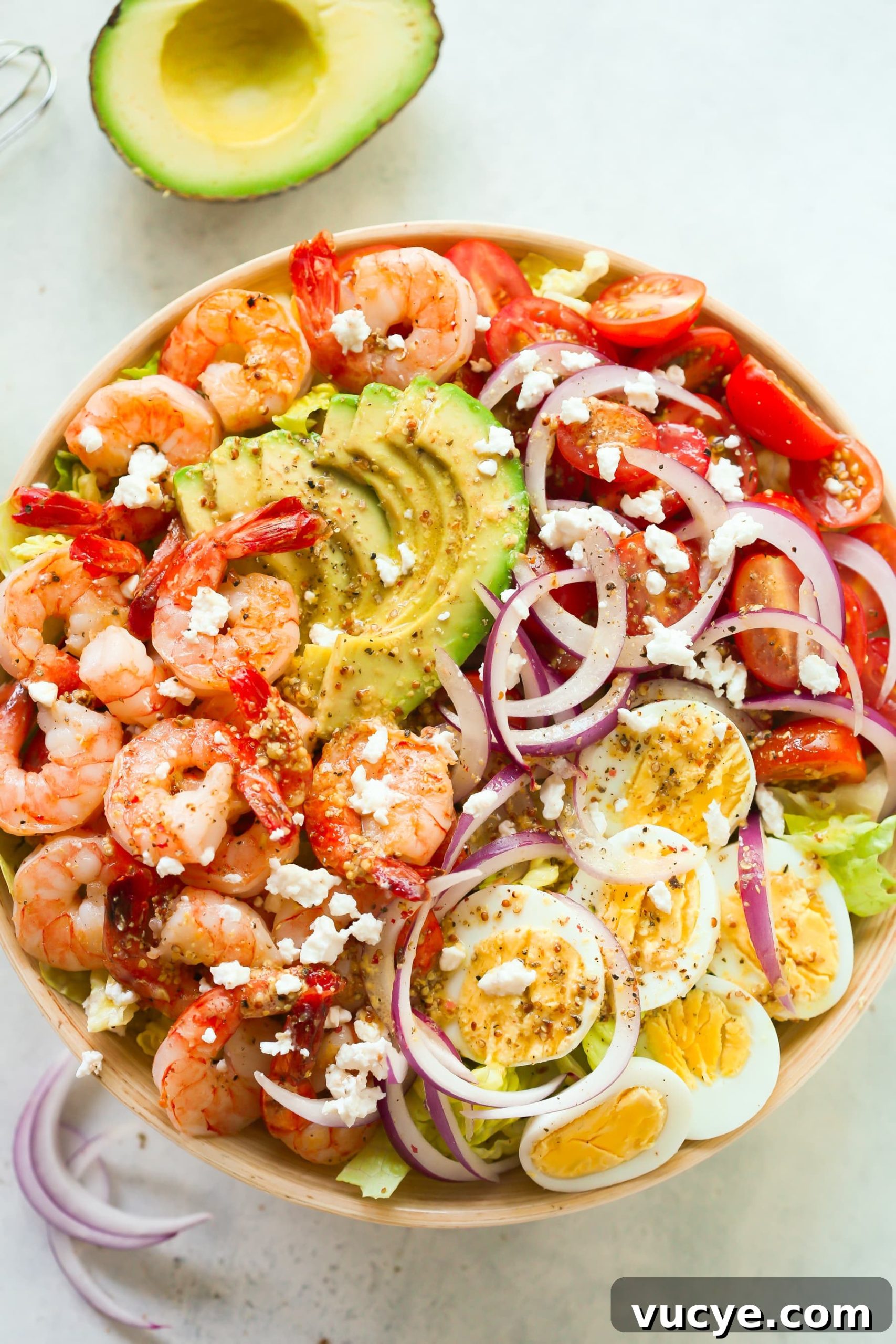 overhead view of a bowl containing shrimp avocado tomato salad.