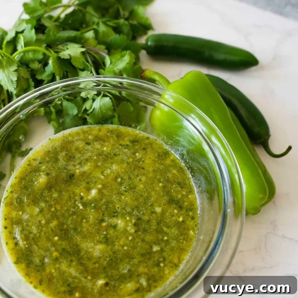 A bowl of homemade tomatillo salsa verde, garnished with fresh cilantro, ready to be served with chips or tacos.
