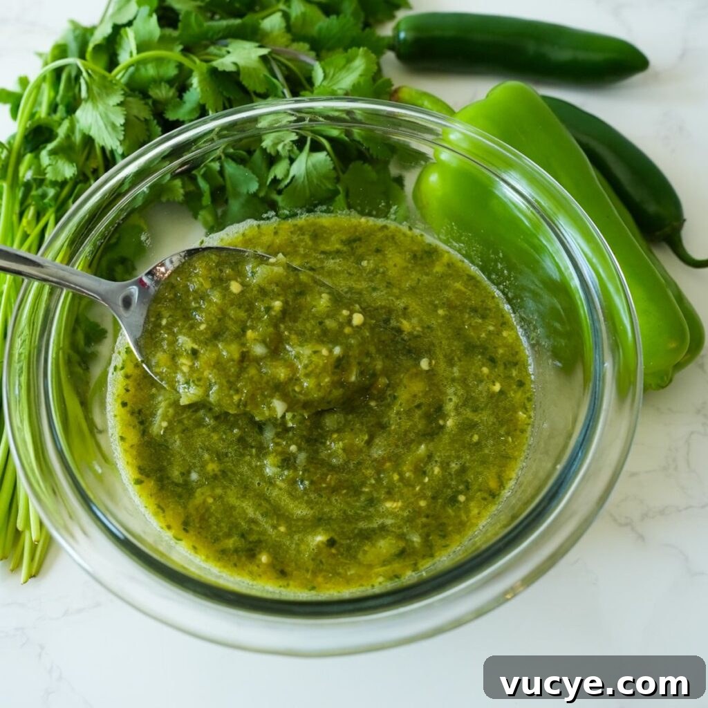 A bowl of homemade tomatillo salsa verde, garnished with fresh cilantro, ready to be served with chips or tacos.