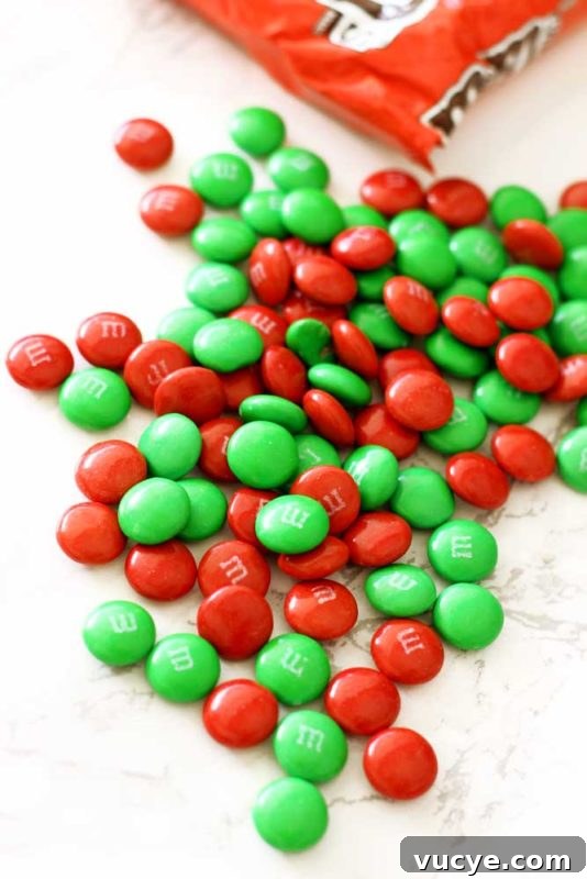 Bag of red and green M&Ms sitting on a white marble table.