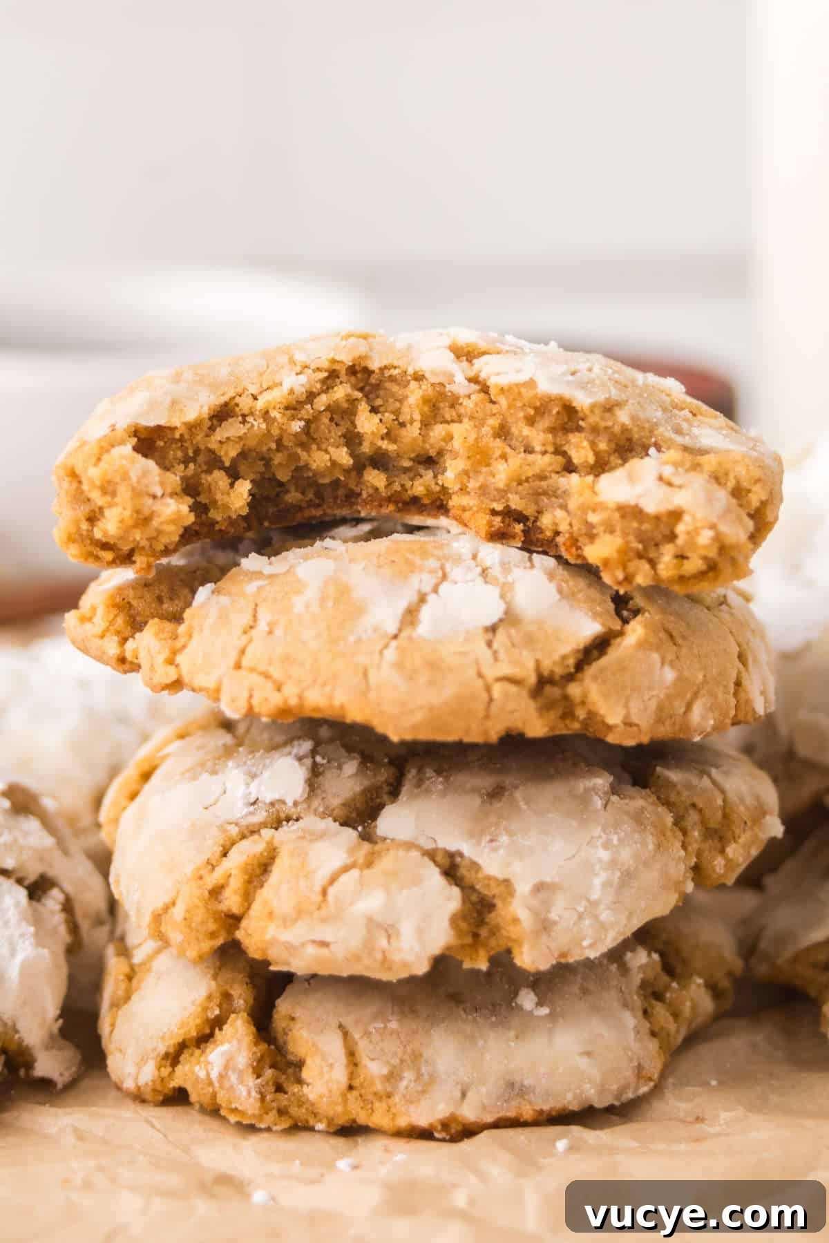 Stack of soft gingerbread crinkle cookies highlighting thick, tender texture and powdered sugar tops