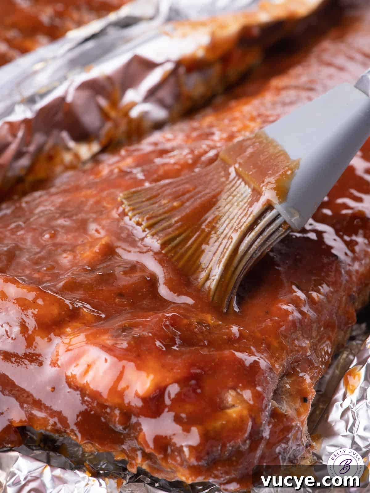 Bourbon BBQ sauce being slathered on a rack of ribs